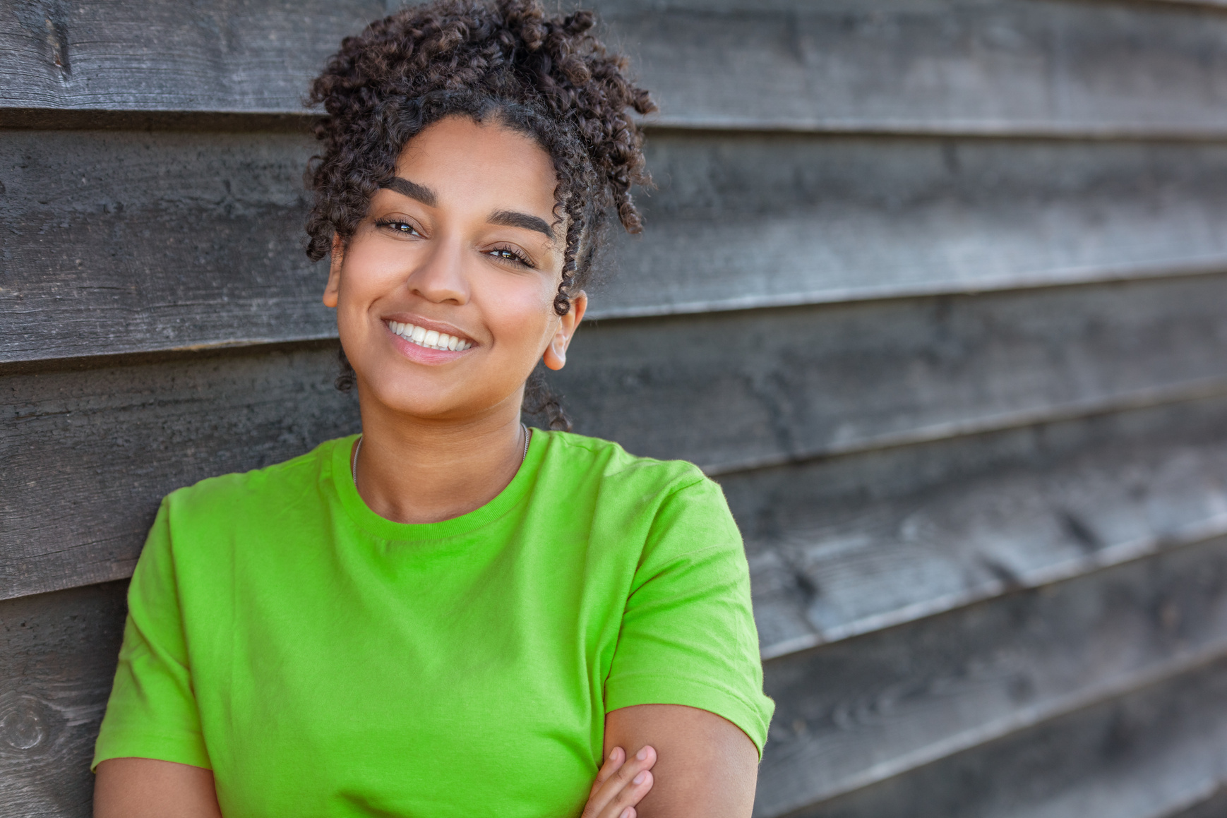 Young Woman Wearing Green Shirt  Leaning on the Wall